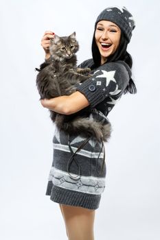 Young lady with a cat, studio photo on neutral backgrund