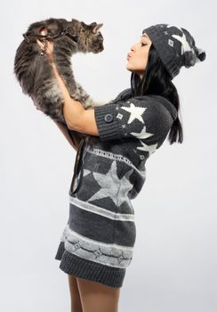 Young lady with a cat, studio photo on neutral backgrund