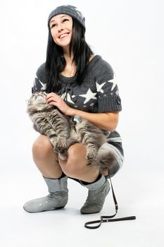 Young lady with a cat, studio photo on neutral backgrund