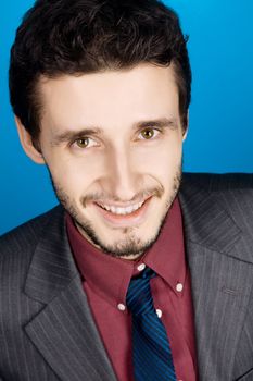 Young handsome businessman studio portrait, blue background