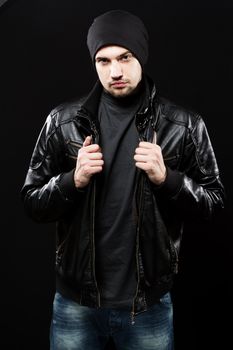 Handsome young man in black leather jacket, studio portrait
