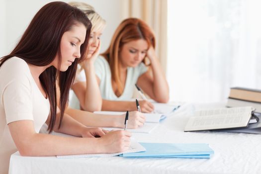 Portrait of bored Students learning at a table in a kitchen