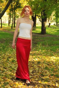 Beautiful girl in red, walking in a park