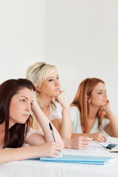 Bored university students sitting at a table during class