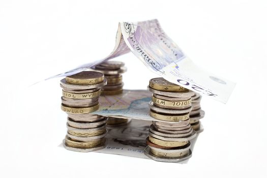 Coins and bank notes built into a house.