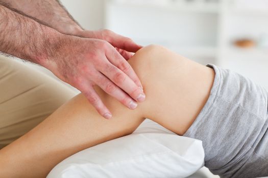 Man massaging a lying woman's knee in a room