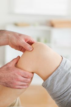 Guy massaging a woman's knee in a room