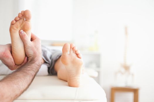 Male masseur doing a reflexology massage in a room