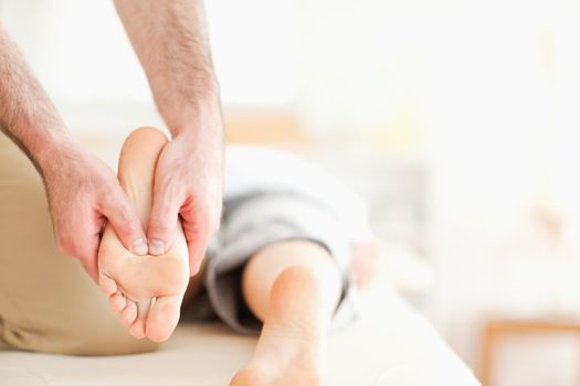 Male masseur massaging a woman's feet in a room