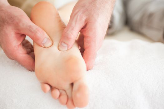 Man massaging a woman's foot in a room