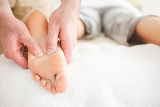 Male masseur massaging a woman's foot in a room