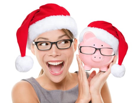 Christmas glasses eyewear sale concept. Woman wearing eye glasses and santa hat is holding piggy bank with glasses. Excited multiracial young woman isolated on white background.