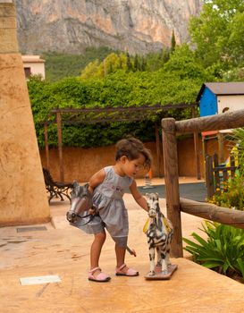 Cute Hispanic girl loving to play with historic toys