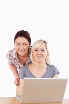 Portrait of smiling women with a laptop in a studio