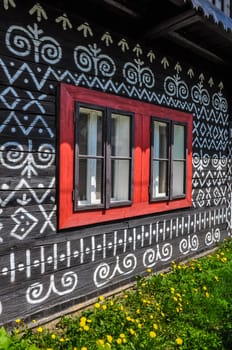 Traditional painted cottage wall and window detail with wall and grass