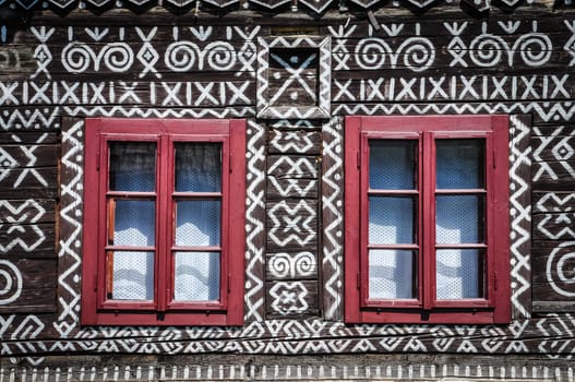 Traditional painted cottage wall and window detail, red color windows