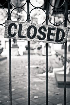 Monochrome closed sign on metal bars of the gate