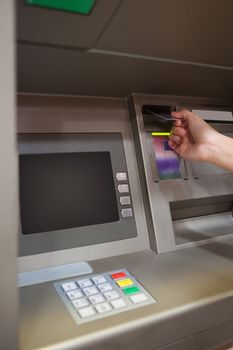 Portrait of a hand inserting a credit card in an ATM