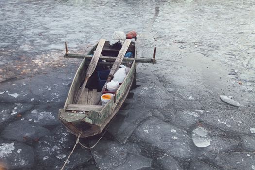 An old wooden fisherman' s boat in the frozen lake