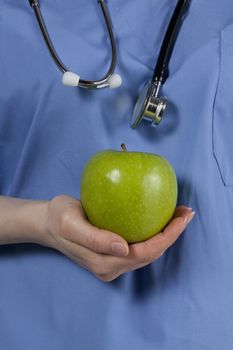 Female physician holding a green apple
