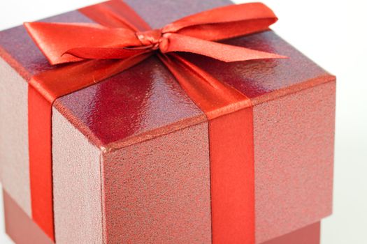 A red gift box wrapped in a red ribbon