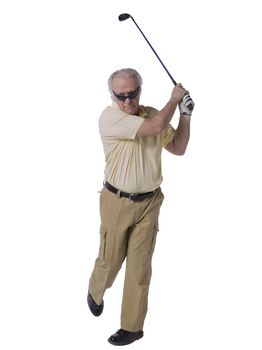 Portrait of a senior man hitting a golf ball in a full length image  