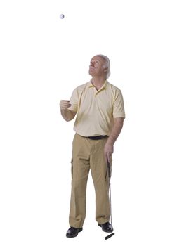 Old male golfer tossing a golf ball in the air