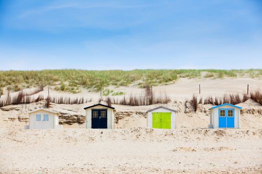 Colorfull Dutch houses on the beach with blue sky. Texel, Holland