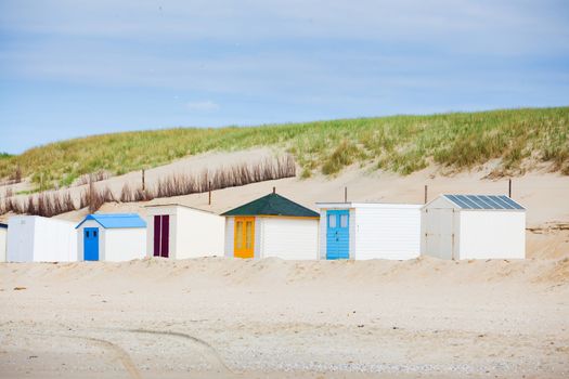 Colorfull Dutch houses on the beach with blue sky. Texel, Holland