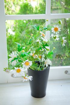 black vase and flower on the white table