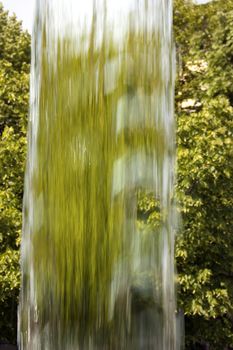 Flow of clear water on background made of green plants
