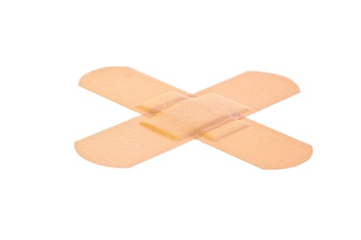 Cross-shaped band-aid on a white background