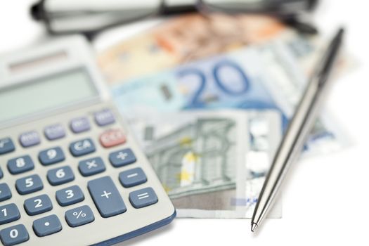 Money, pen, glasses and angled pocket calculator on a white background