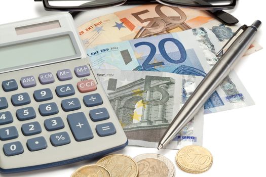 Coins and cash with pen along with glasses and pocket calculator on a white background