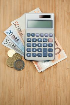 Money and pocket calculator on a desk