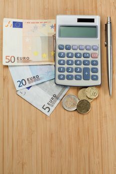 Money with pen and pocket calculator on a desk