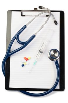 Note pad with blue stethoscope and pills on a white background