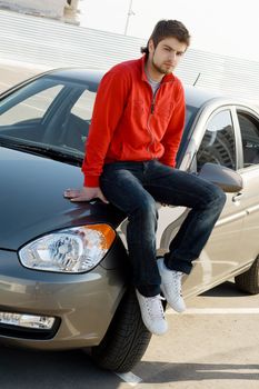 Young handsome driver with his car