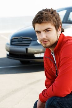Young handsome driver with his car