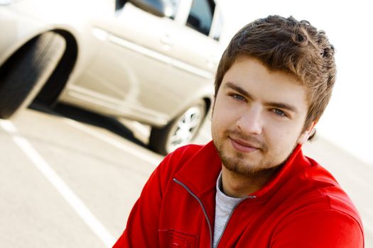 Friendly young handsome man with his car