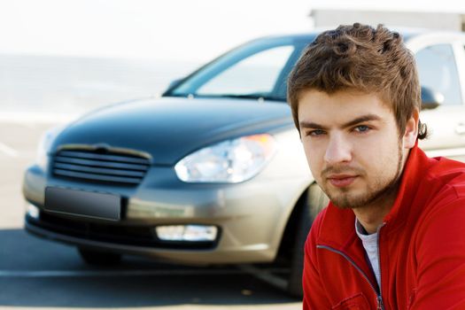 Friendly young handsome man with his car