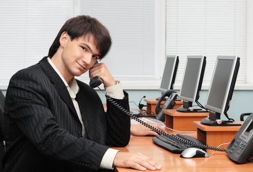 Young handsome businessman speaking by the phone