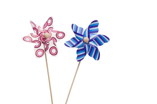 Pink and blue paper windmills on a white background