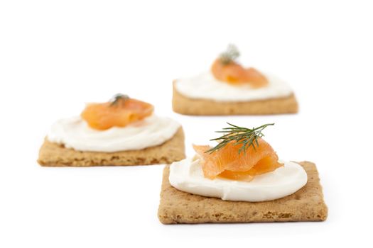 Image of biscuits with smoked salmon and cream cheese top with dill leaves isolated on white 