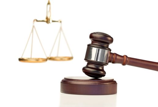 Gavel in action and scale of justice on a white background