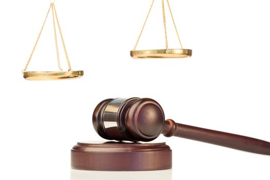 Fixed gavel and golden scale of justice on a white background