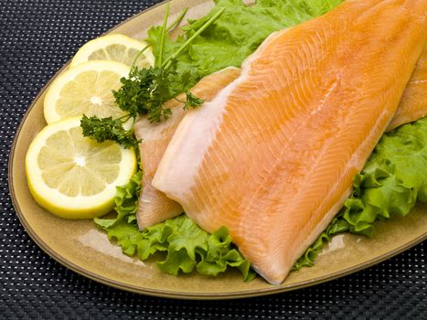 Well decorated salmon on a plate with lemon