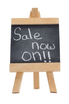 Chalkboard with the words sale now on written on it isolated against a white background