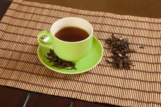 green cup of hot tea on wood background