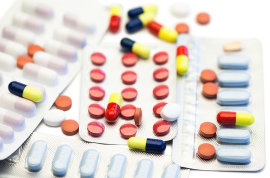 Color pills and blister strips on a white background